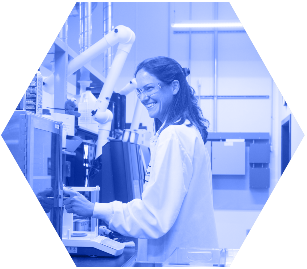 An analyst smiles while working at her lab station.